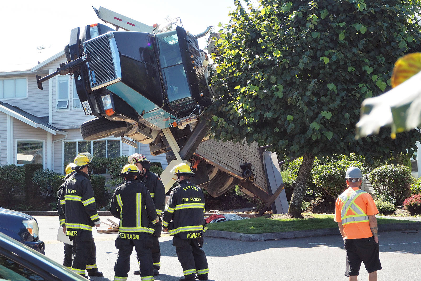 Crane truck tips onto two condominium homes in Nanaimo B.C. Crane and